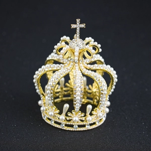 Elegant gold bridal crown with pearls and cross detail on a black background