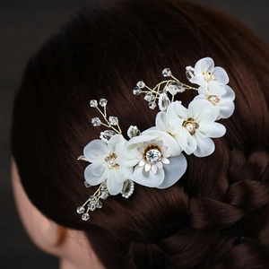 Detail of handmade bridal hair comb with ivory tulle flowers and crystal beads on a braid