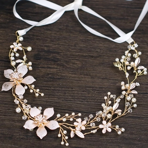 Dettaglio fascia fatta a mano in foglie d'oro con fiori rosa e perle su legno