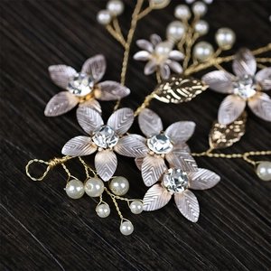 Elegant gold leaf and flower bridal hair vine with pearls and crystals on dark wood