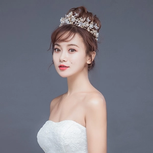 Détail de la couronne de mariée dorée avec fleurs blanches et perles papillons