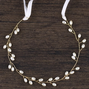 Serre-tête de mariée minimaliste perlé doré avec rubans en satin sur fond bois foncé