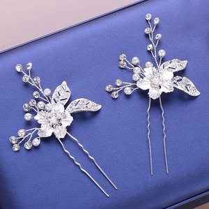 Dettaglio di due forcine da sposa argentate con perle e strass di cristallo lucido