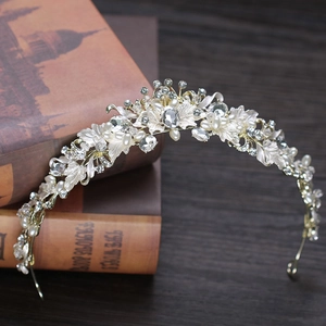 Macro view of bridal tiara with silver floral petals, white pearls and sparkling crystals