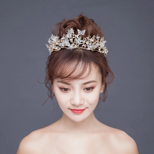 Couronne de mariée dorée élégante avec fleurs blanches, papillons en métal et perles sur modèle