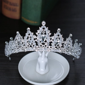 Macro shot of silver bridal tiara with rhinestones placed on a white ceramic horse tray
