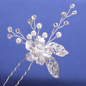 Dettaglio di forcina per capelli da sposa con fiori d'argento, perle bianche e strass scintillanti