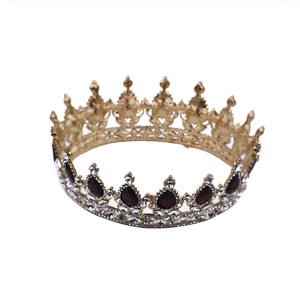 Détail de couronne vintage dorée avec pierres rouges en goutte et accents de cristal