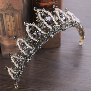 Vintage baroque silver crown with dark rhinestones on a rustic wooden surface