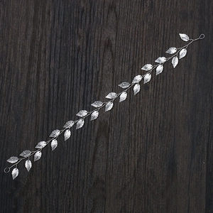 Silver leaf bridal headband featuring detailed metallic foliage on a rustic wooden background