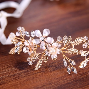 Detail of bridal headband with white enamel flowers, gold leaves and crystal beads
