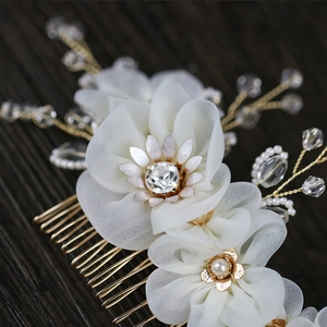 Detail of handmade bridal hair comb with white chiffon flowers and pearl accents