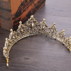 Detailed view of a vintage golden bridal crown with crystals on a classical art book