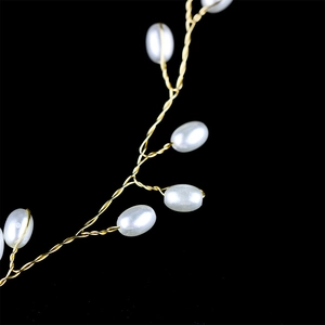 Détail de serre-tête mariage doré avec perles blanches élégantes et motifs de vignes