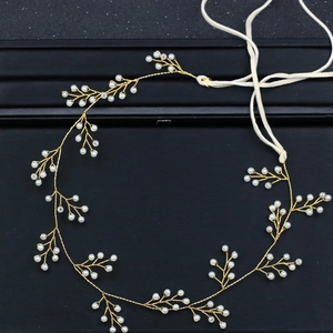 Detailansicht eines handgefertigten Brautstirnbands aus Golddraht mit weißen Perlen