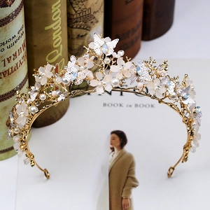Vue détaillée d'une couronne dorée avec fleurs blanches et cristaux sur un livre
