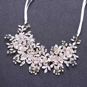 Detail von rosa Stoffblumen und Kristallreben-Kopfschmuck mit weißen Seidenbändern