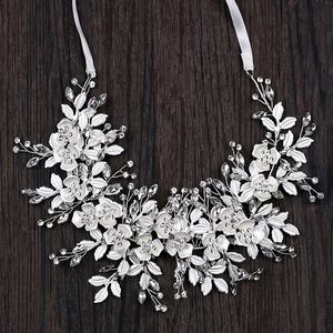Elegant bridal hairband with white 3D flowers and sparkling crystals on wooden background
