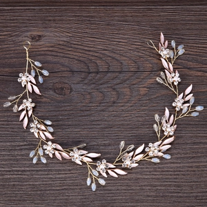 Elegant gold bridal vine headband with pink leaves and sparkling rhinestone accents