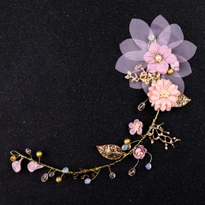 Détail macro du bandeau floral en tissu rose fait main avec feuilles d'or et perles