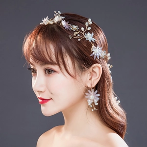 Détail d'un ensemble de bandeau et boucles d'oreilles de mariée avec fleurs en résine