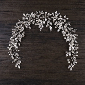 Détail de vigne à cheveux mariée argentée avec perles et strass sur fond en bois