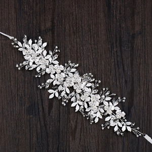 Eleganter silberner Braut-Haarschmuck mit weißen Blumen und Kristallen auf Holzgrund