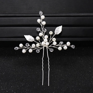Détail d'épingle à cheveux de mariée avec feuilles argentées, perles et cristaux
