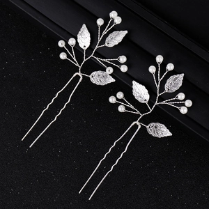 Détail d'épingles à cheveux de mariée avec perles blanches et feuilles en métal argenté