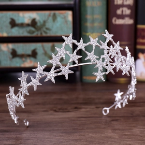 Close-up of silver star-shaped bridal tiara with sparkling rhinestones on vintage wood