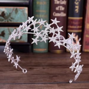 Elegant silver bridal crown headband with sparkling star rhinestones on a wooden desk