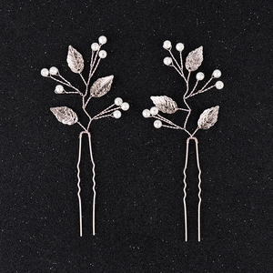 Détail d'épingles à cheveux de mariée or rose avec feuilles métalliques et perles