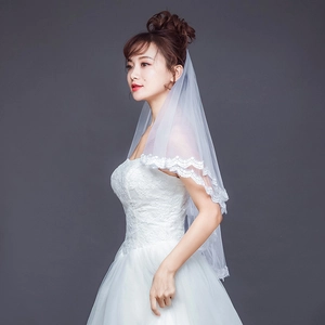 Elegant double-layered white bridal veil with delicate lace edges on studio model