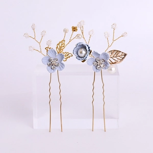 Blue floral hair comb set with gold leaves, pearls and rhinestones on white background