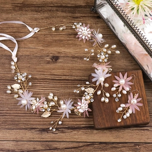 Vue détaillée du set d'accessoires de mariée avec fleurs en tissu rose et perles sur bois