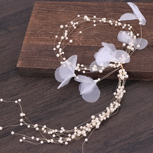 Detail of handcrafted long pearl tassel hairpiece with mesh petals for wedding hairstyles