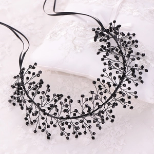 Close-up of black beaded bridal headband with crystal details on white lace fabric