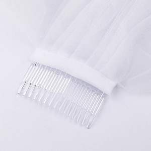 Detailed view of white bridal lace wedding veil with transparent comb attachment