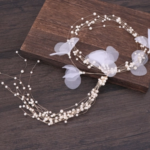 Detail of bridal hair vine featuring multi-layer pearls and delicate white gauze petals