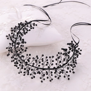 Detail view of handmade black beaded bridal headband with branch design and ribbons