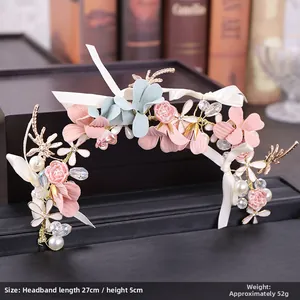 Détail d'un bandeau floral pour enfant avec des pétales roses et des perles