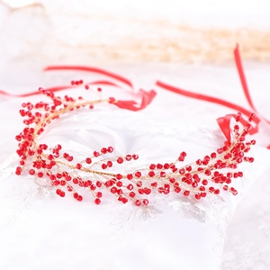 Detail of handmade gold wire hairpiece with red crystal beads and ribbon ties