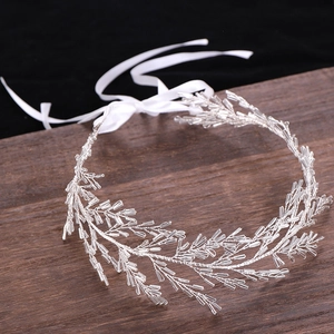 Détail macro du bandeau de mariée en fil d'argent avec perles et rubans de soie blancs