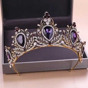 Close-up of vintage baroque crown with purple teardrop gemstones and white rhinestones