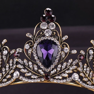 Macro detail of vintage baroque tiara with deep purple gems and antique gold filigree