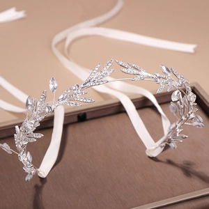 Macro detail of silver leaf bridal headband with sparkling rhinestones and white satin ribbon