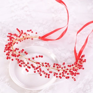 Handmade bridal headband with red berries and gold leaves on a white lace background