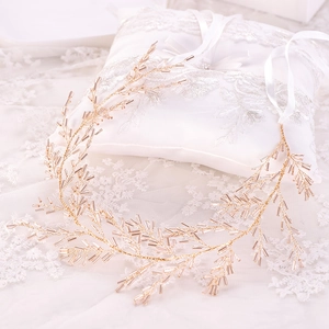 Vue macro de l'accessoire de cheveux de mariée doré à perles de cristal sur dentelle