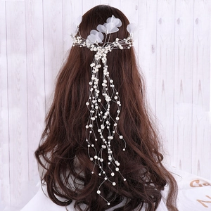 Detailed view of bridal hair accessory with white pearls and translucent mesh petals