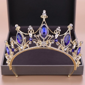 Dettaglio corona barocca dorata con gemme blu e strass bianchi in una scatola regalo
